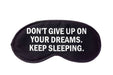 Black sleep mask with motivational quote on a white background