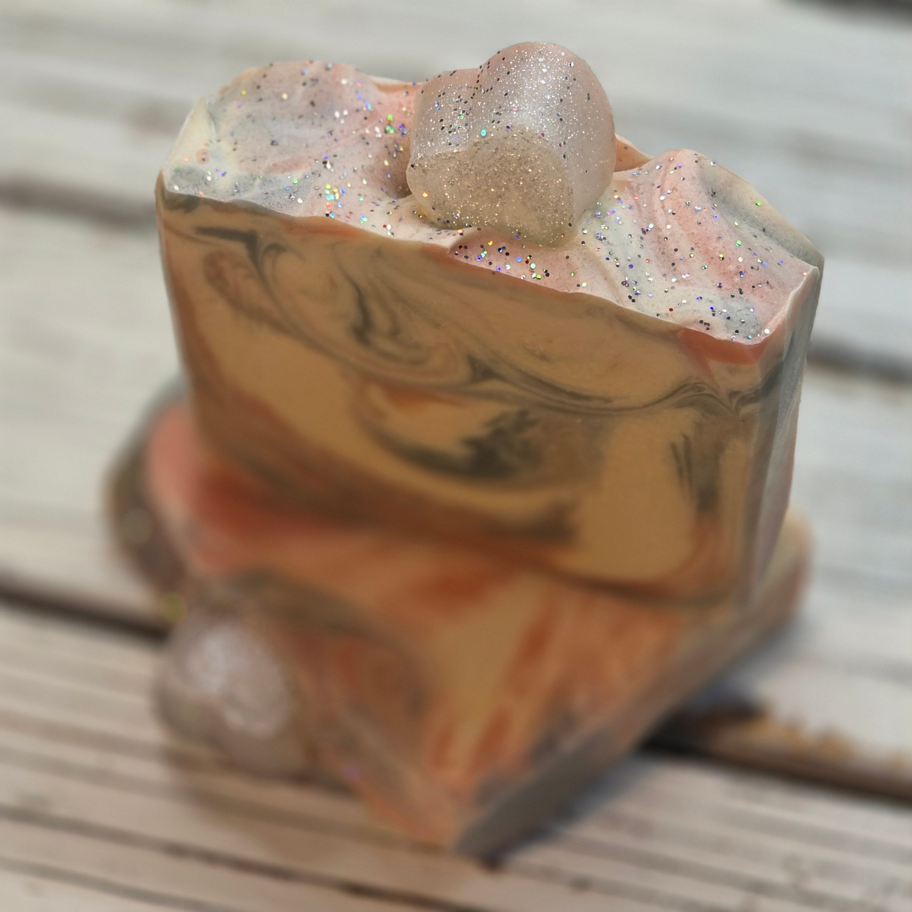 Marble-textured soap bar with glittery finish on a wooden surface