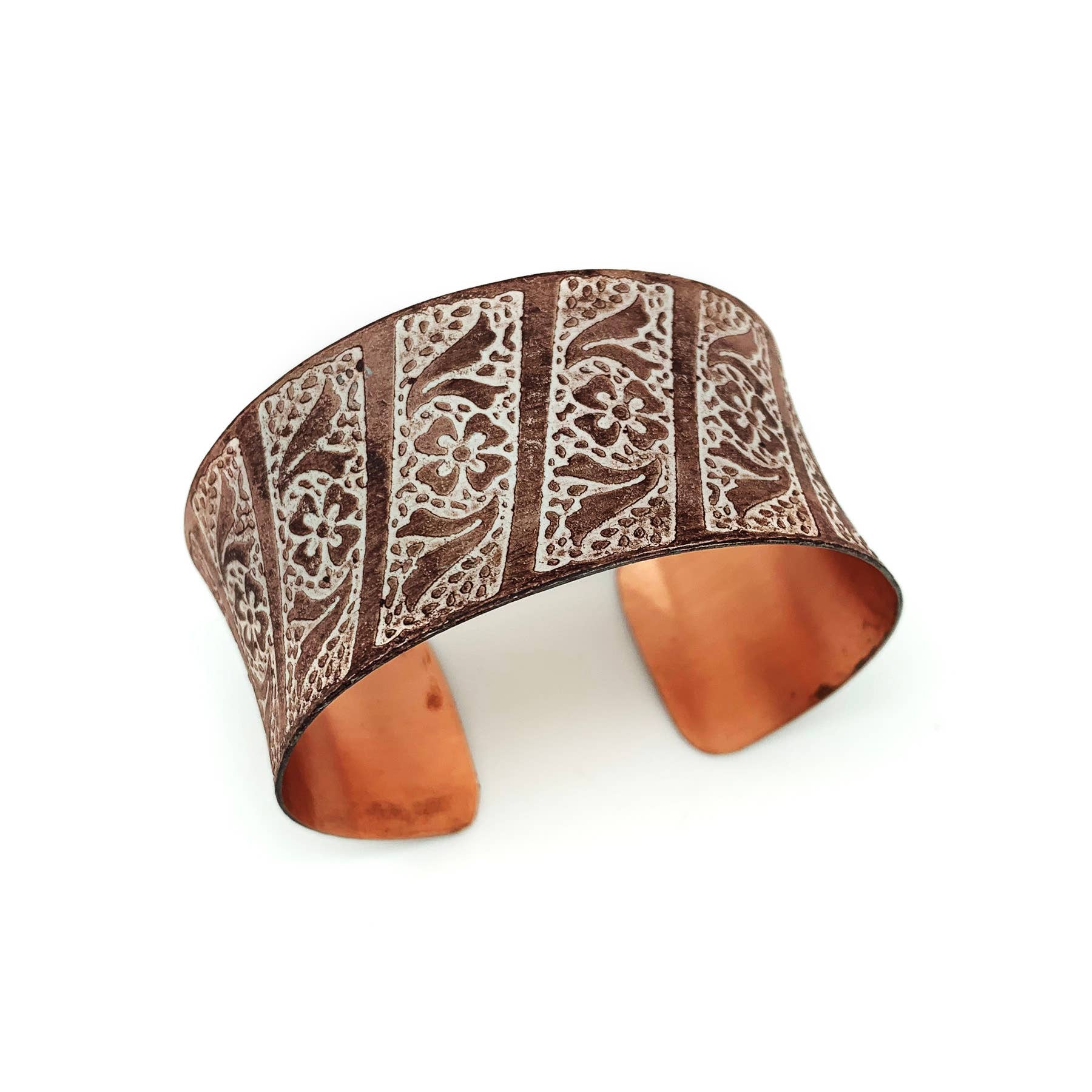 Copper bracelet with intricate patterns on a white background