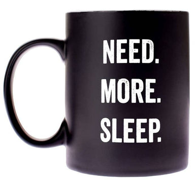 Black mug with 'NEED. MORE. SLEEP.' text on a white background