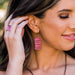 Close-up of a woman wearing coral copper earrings with a blurred background