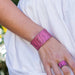 Close-up of a hand wearing a coral textured bracelet and ring against a white background.