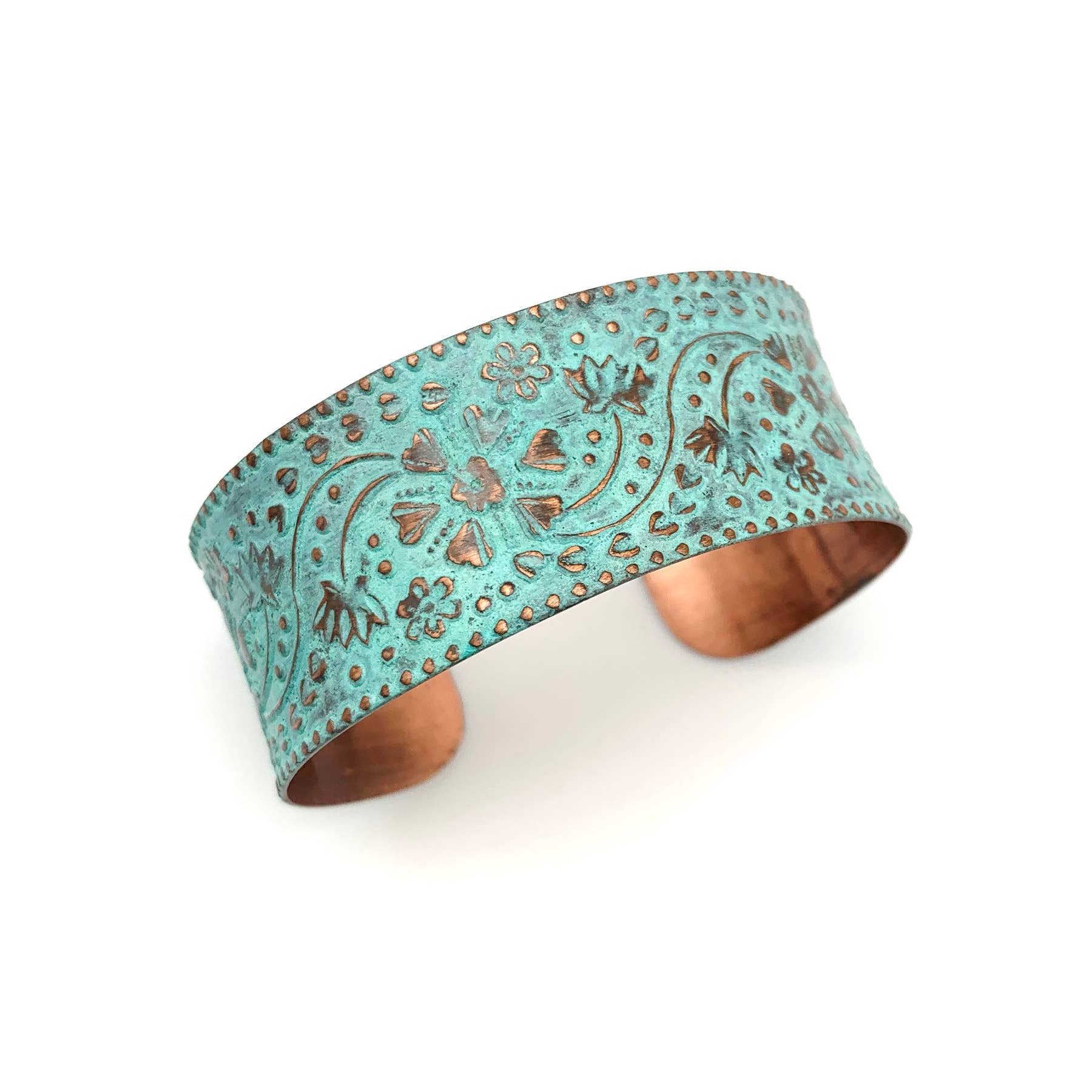 Turquoise cuff bracelet with embossed patterns on a white background