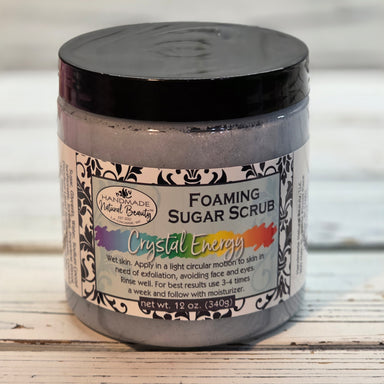 Crystal Energy Foaming sugar scrub container with decorative label on a wooden surface