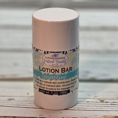 Lotion bar in a cylindrical container with a label on a wooden surface scented Shoreline.