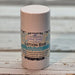 Lotion bar in a cylindrical container with a label on a wooden surface scented Shoreline.