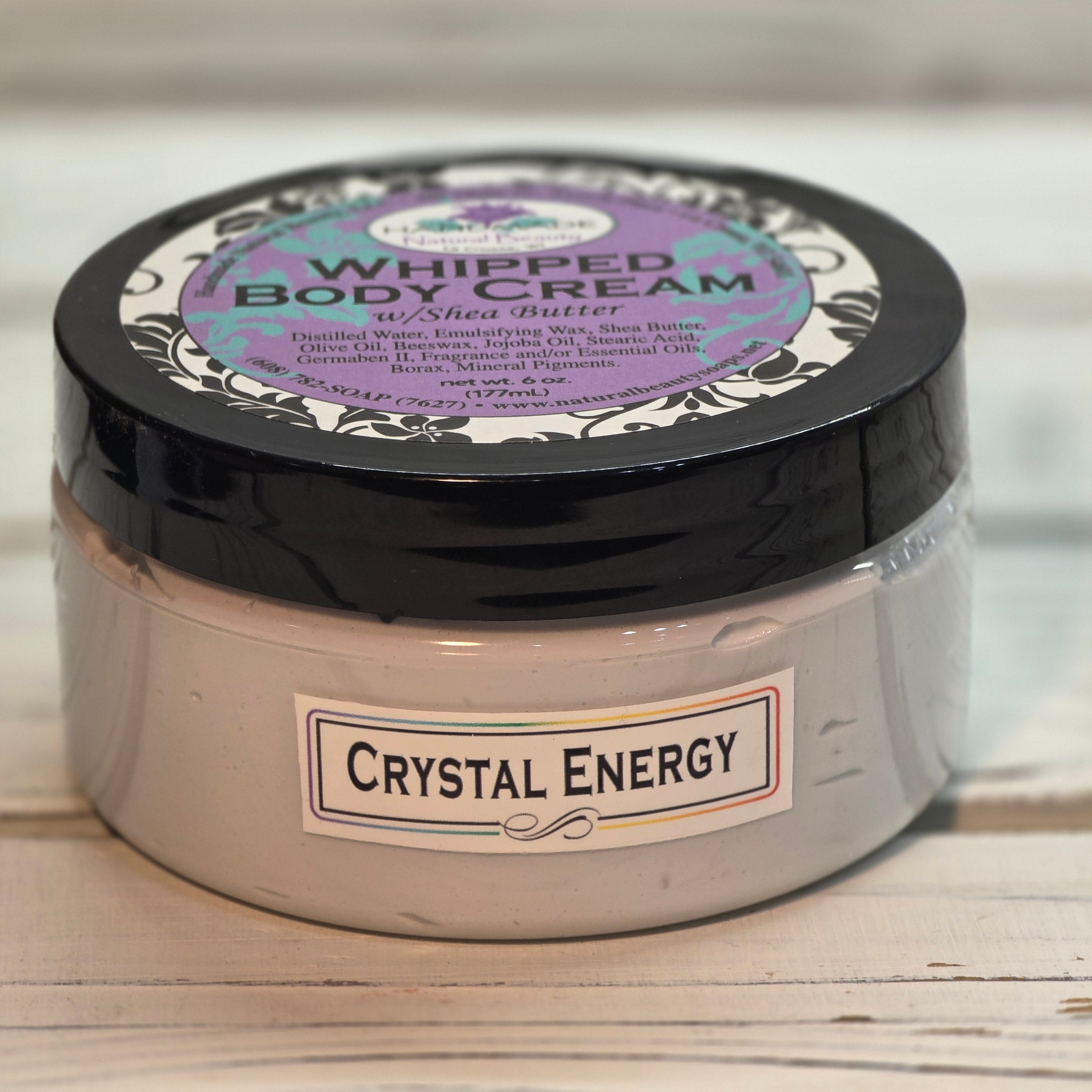 Jar of whipped body cream labeled 'Crystal Energy' on a wooden surface.