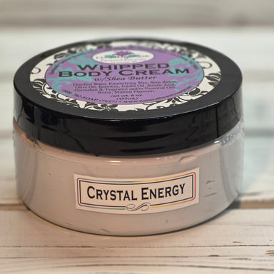 Jar of whipped body cream labeled 'Crystal Energy' on a wooden surface.