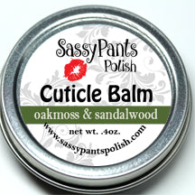 A cuticle balm labeled as Oakmoss & Sandalwood in a small silver metal tin.