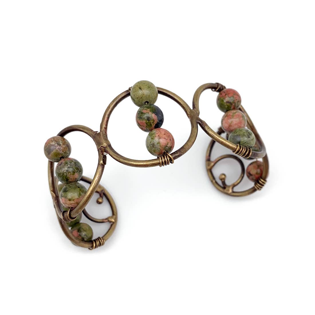 An adjustable wire-wrapped cuff bracelet with multicolored stone beads and a antique brass finish.