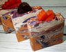 Orange purple and white swirled goat milk soap by Handmade Natural Beauty featuring various shapes of autumn leaves glycerin soaps on top.