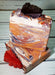 Orange purple and white swirled goat milk soap by Handmade Natural Beauty featuring various shapes of autumn leaves glycerin soaps on top.