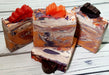 Orange purple and white swirled goat milk soap by Handmade Natural Beauty featuring various shapes of autumn leaves glycerin soaps on top.